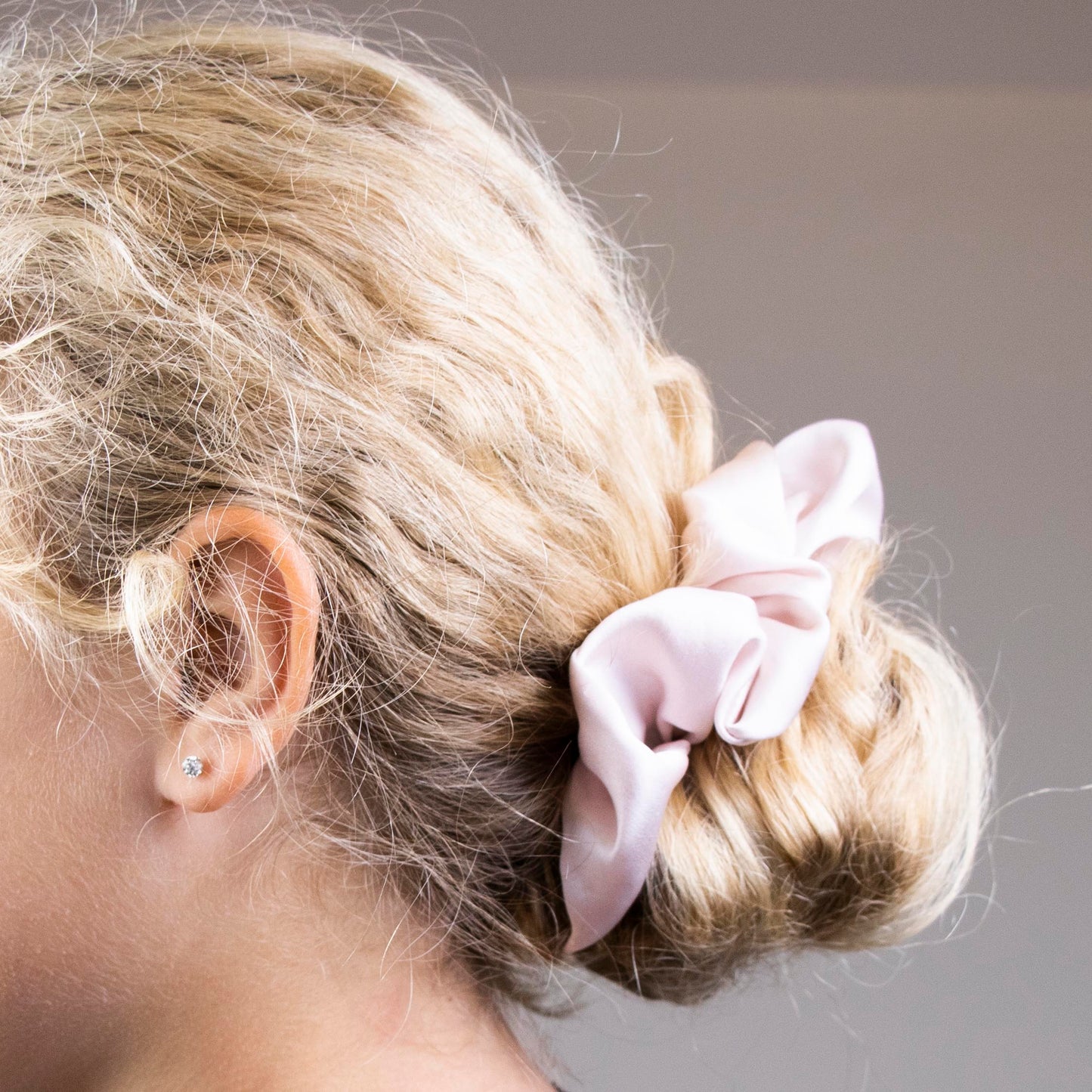 Peace Silk scrunchie blush rose – in blonde hair as hair tie around bun, side view