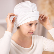 Frau setzt Seiden-Schlafhaube Turban naturweiß von Seidenstern auf – Peace Silk Jersey