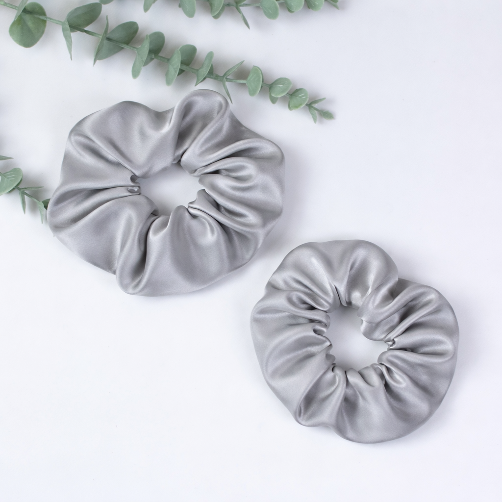 Peace Silk Scrunchie Silbergrau – großes und kleines Exemplar, Draufsicht, Eukalyptuszweig, weißer Hintergrund