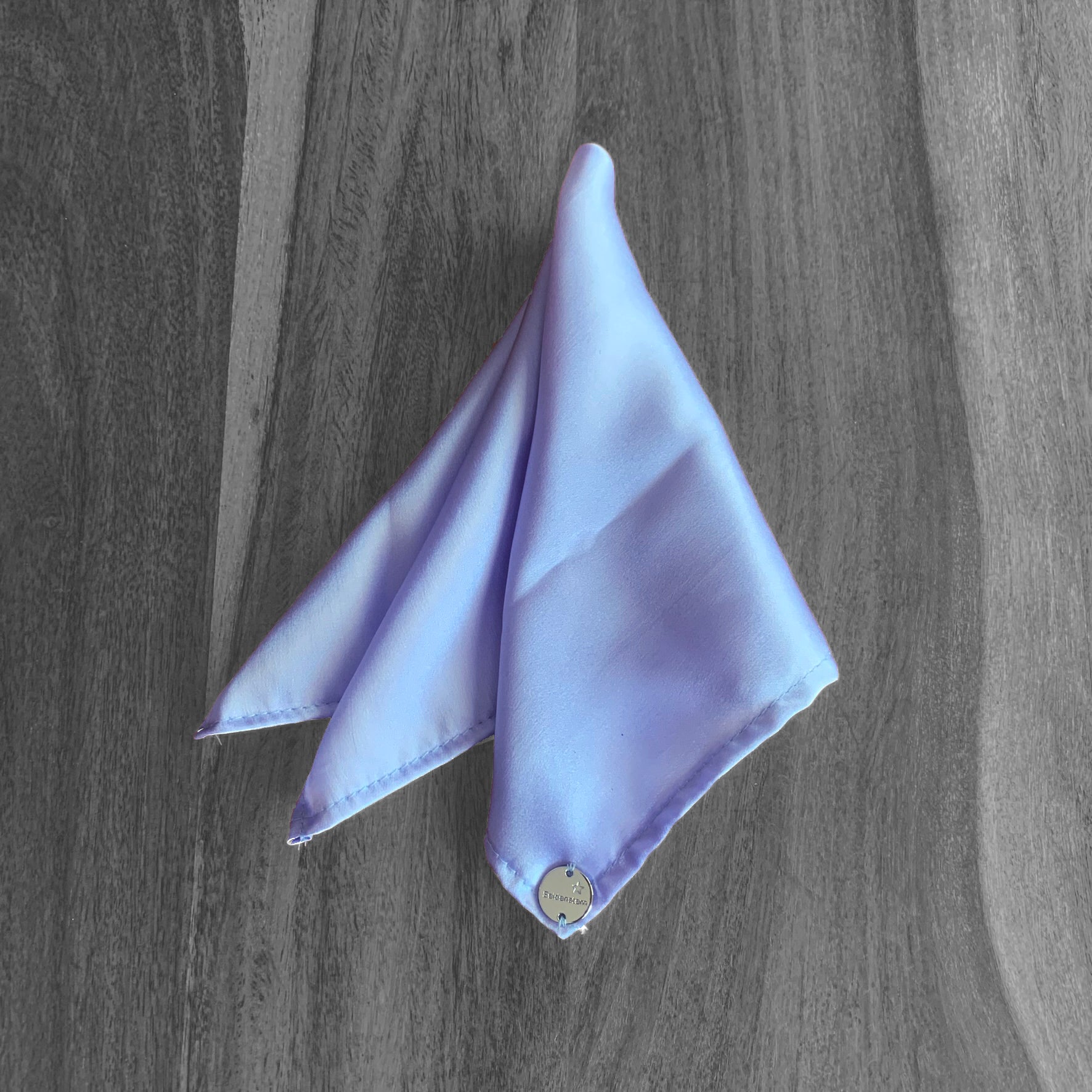 Peace Silk scarf satin lavender blue – folded as triangle on wooden surface, top view