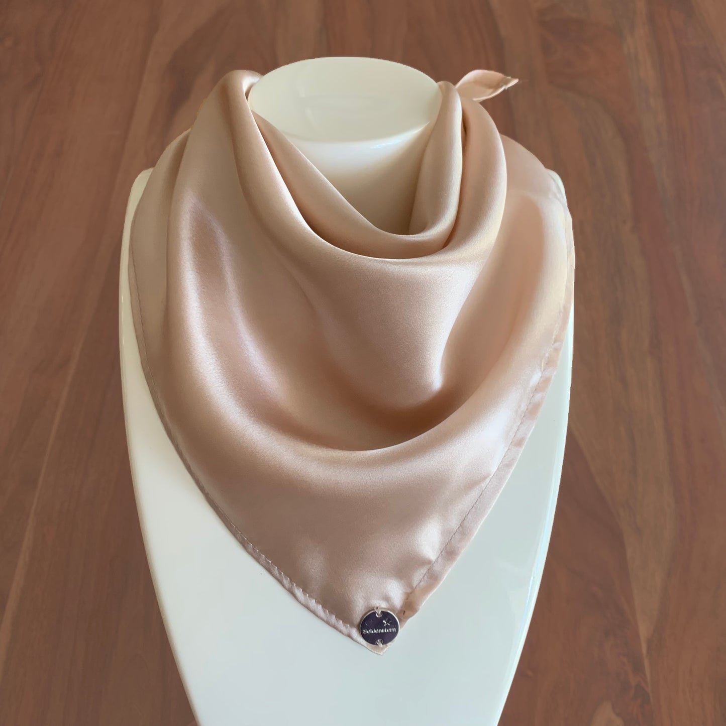 Peace Silk scarf satin beige blush – as triangle around mannequin, Seidentraum pin, wooden background